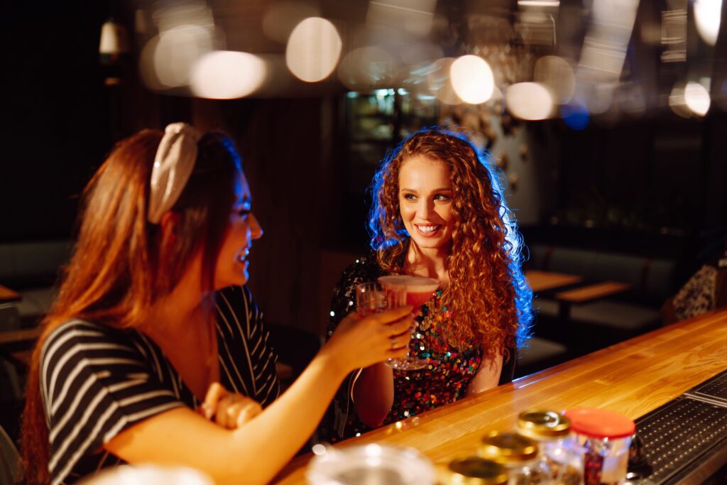 Coctails party. ?ocktail in the hands of a woman. Young woman drinking cocktails in bar.